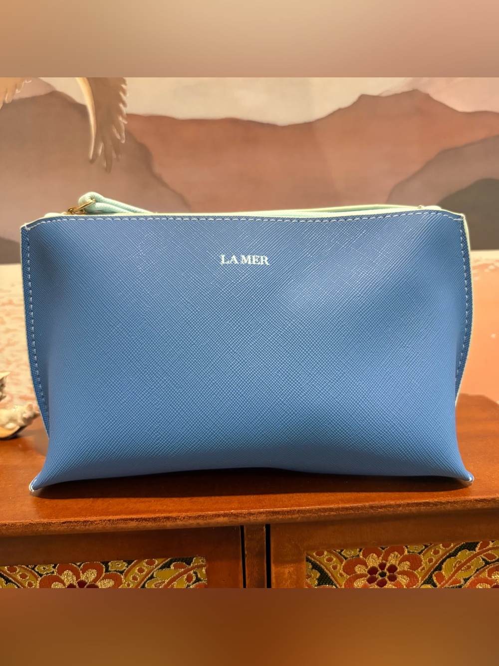 La Mer cosmetic and travel makeup pouch featuring aqua-tinted trim and interior